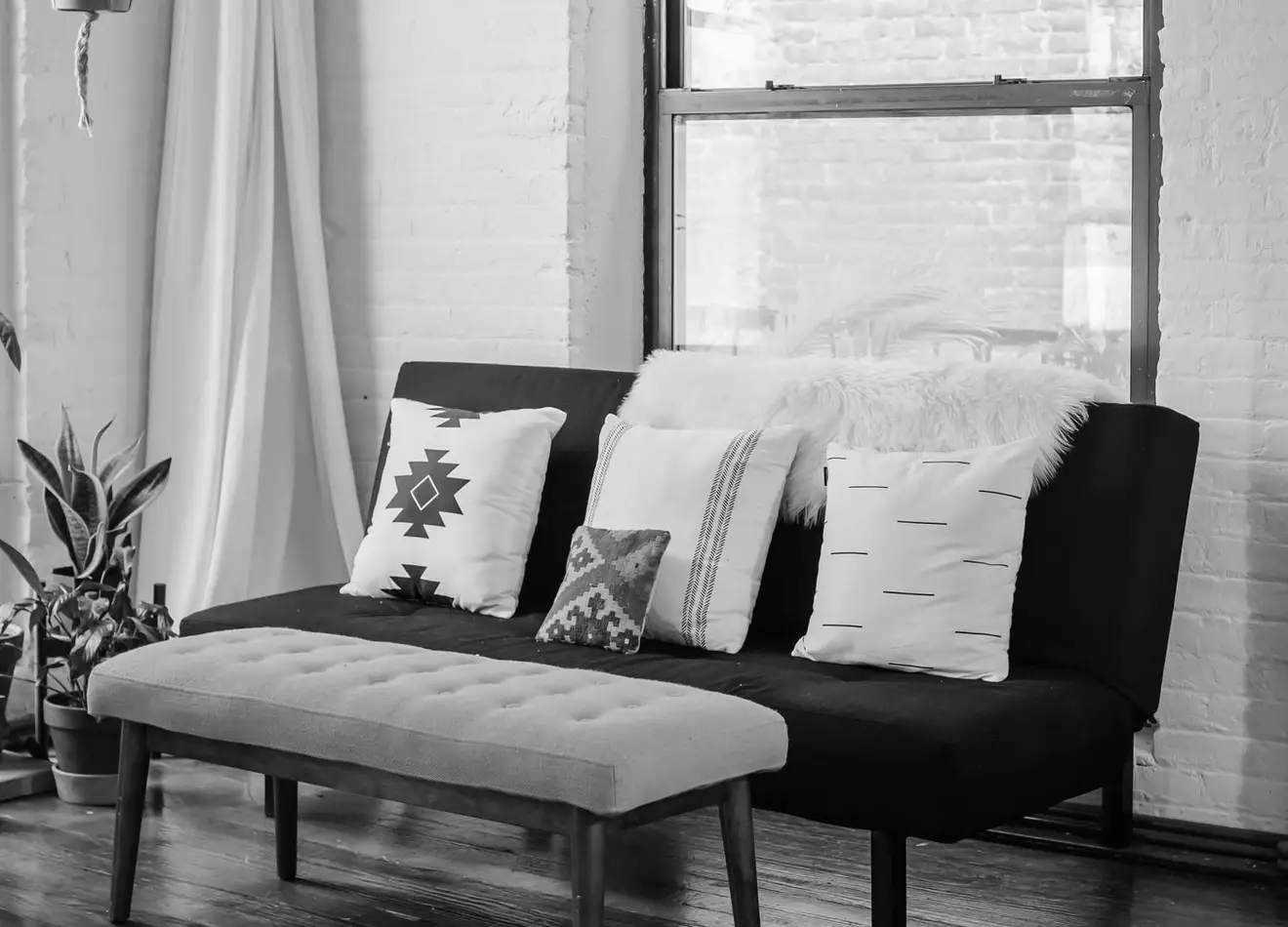 An upholstered sofa and bench by a loft window